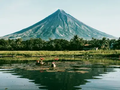 A captivating view of Mayon Volcano with a serene lake reflection in the Philippines.