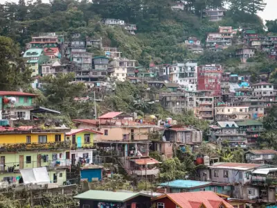 Dense hillside residential area in Baguio, Philippines showcasing colorful buildings and lush greenery.