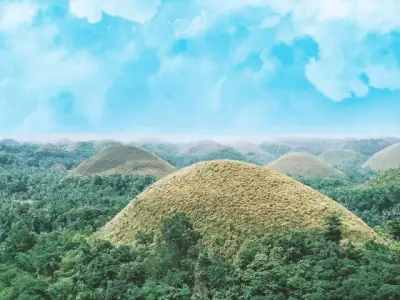 Breathtaking aerial view of the unique Chocolate Hills under a vibrant blue sky in Bohol, Philippines.