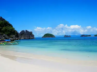 Scorching hot Caramoan beach under the summer sun boat on shore