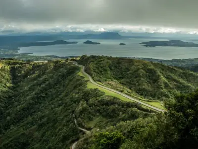 Breathtaking aerial view of Tagaytay's lush highlands and winding roads overlooking Taal Lake.