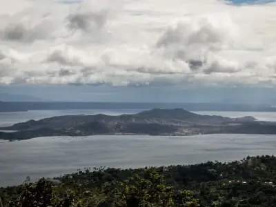 Breathtaking view of Taal Volcano surrounded by Taal Lake in Tagaytay, Philippines, under a cloudy sky.