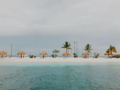 Serene beach with nipa huts and palm trees in Lapu-Lapu City, Philippines.