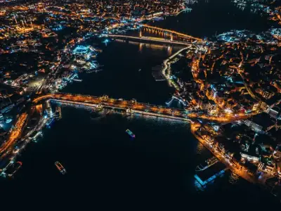 Captivating aerial view of a vibrant city and bridges lit at night over a river.