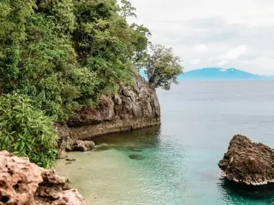 Tranquil turquoise lagoon with lush cliffs on Samal Island, Philippines.
