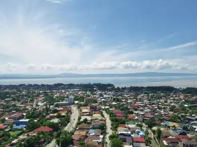 Aerial view of Davao City with a vast coastline and scenic Samal Island in the background.