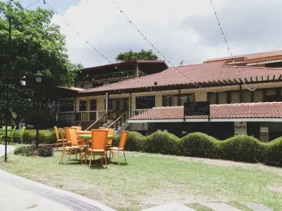Charming resort dining area in Calamba, Philippines with outdoor seating and lush garden view.