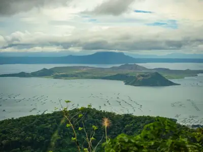 Breathtaking view of Taal Volcano and Lake in the Philippines, surrounded by lush greenery.