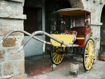A traditional kalesa horse carriage set against the rustic stone architecture of Taal, Philippines.