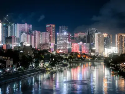 Beautiful night view of Makati City's illuminated skyline reflecting on the river.