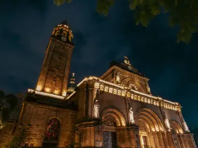 A dramatic night view of the illuminated Manila Cathedral showcasing its architectural beauty.