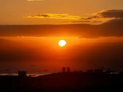 A breathtaking sunset over Manila Bay with ships silhouetted against the vibrant sky.