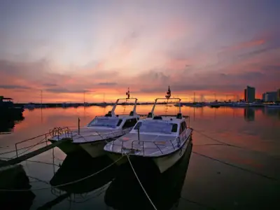 A stunning view of boats docked at Manila Bay during a vibrant sunset.