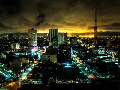 Stunning night view of Quezon City skyline with illuminated buildings and vibrant city lights.