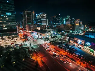 A stunning aerial view of the illuminated cityscape of Taguig City, Philippines at night, showcasing urban life.