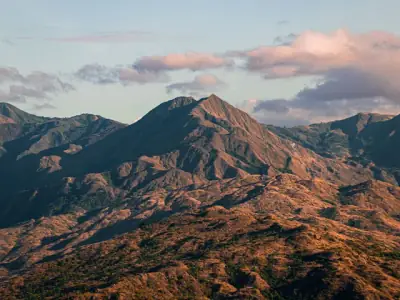 A scenic view of mountains in Occidental Mindoro, Philippines, under a vibrant sky.