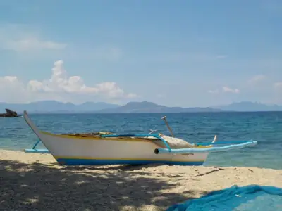 A traditional Filipino boat on a sunny beach in Puerto Galera, Philippines.