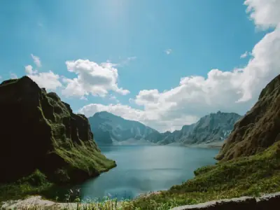Stunning landscape of Mt. Pinatubo's tranquil crater lake under a bright blue sky.