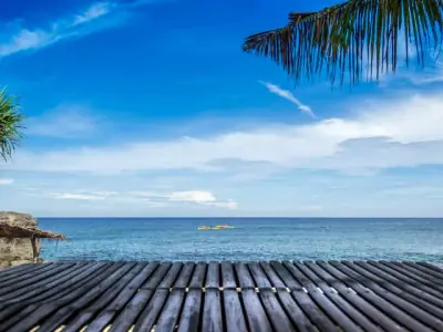 Serene tropical beach in Bolinao, Philippines with clear blue water and skies.