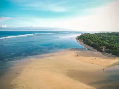 Stunning aerial view of Bolinao beach with clear blue waters and sandy shoreline.
