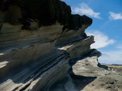 Breathtaking rock formations showcasing erosion patterns against a clear blue sky in Biri, Philippines.