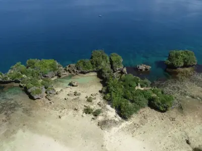 Stunning aerial shot of a hidden lagoon with lush greenery and rocky formations in Sorsogon City, Philippines.